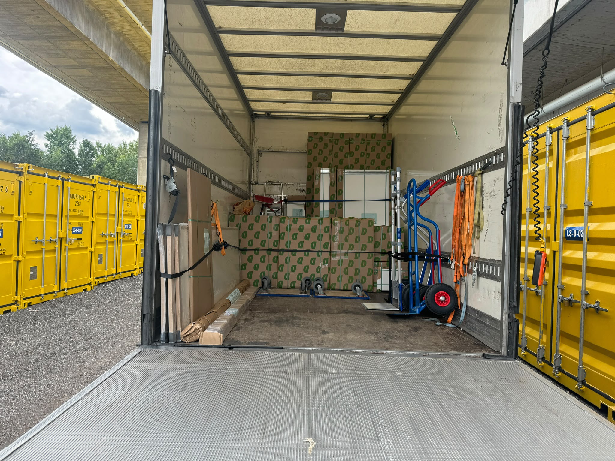 Umzugsgut im LKW vor den Lagercontainern