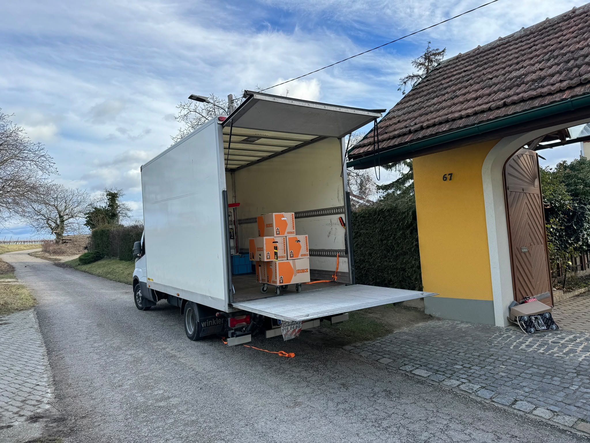 Umzugs-LKW mit Hebebühne vor einem Einfamilienhaus